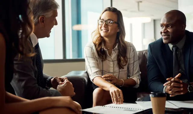 Three business professionals having a discussion at a table.