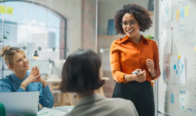 Businesswoman giving a talk to coworkers in an office setting.